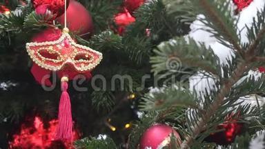 威尼斯红色狂欢节面具挂在圣诞树上。 圣诞节和新年`背景。 圣诞街饰